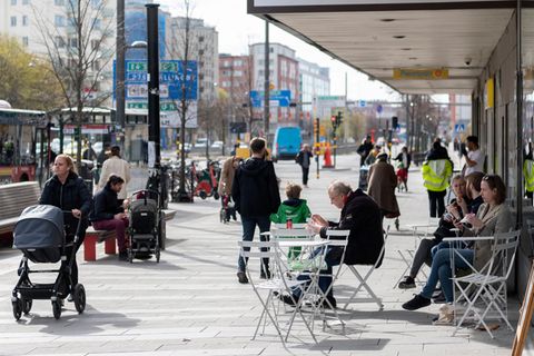 Schweden, Stockholm: Menschen sitzen im Stadtzentrum vor einem Eiscafe