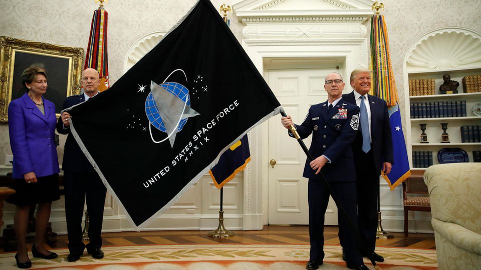 Donald Trump (r), Präsident der USA, steht bei der Vorstellung der Flagge der US-Space Force im Oval Office