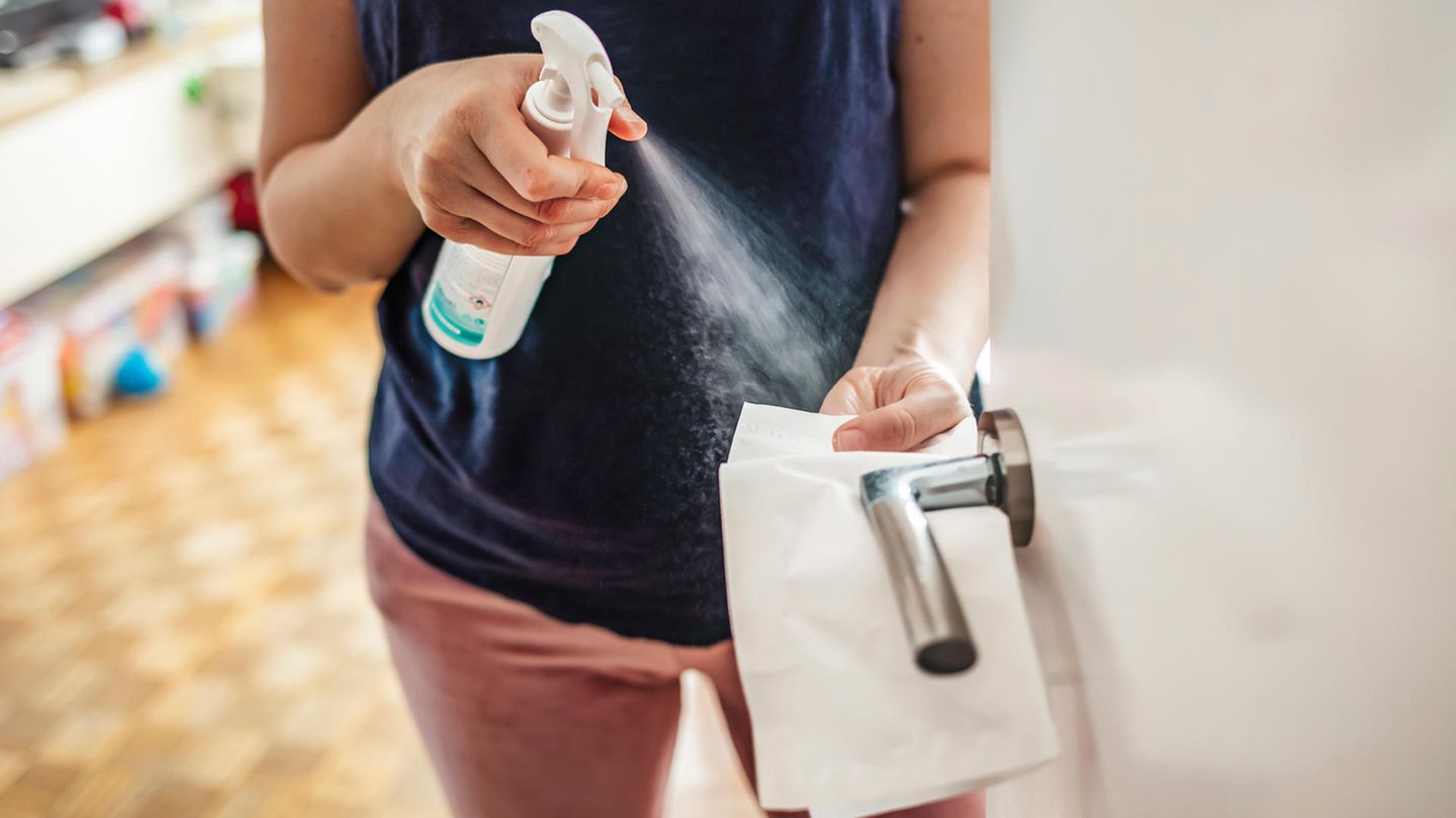 Coronavirus: Eine Frau desinfiziert eine Türklinke