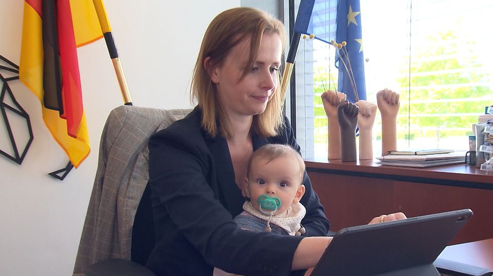 FDP-Abgeordnete Gyde Jensen sitzt mit ihrer Tochter vor dem Schreibtisch im Bundestag.