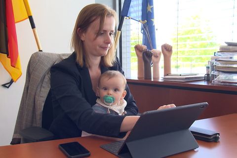 FDP-Abgeordnete Gyde Jensen sitzt mit ihrer Tochter vor dem Schreibtisch im Bundestag.