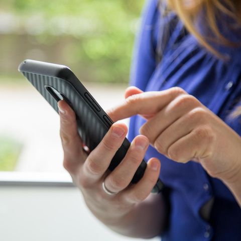 Frau bedient Smartphone - Nummer unterdrücken