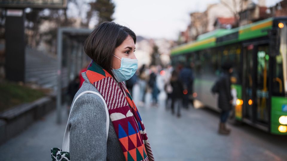 Coronavirus: Eine Frau mit Maske steigt in einen Bus