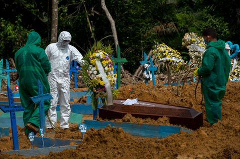 Friedhofsmitarbeiter in Schutzanzügen begraben einen Toten auf dem Friedhof "Nossa Senhora Aparecida" in Manaus