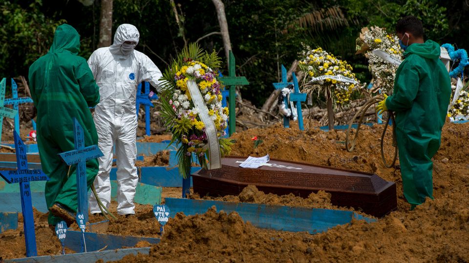 Friedhofsmitarbeiter in Schutzanzügen begraben einen Toten auf dem Friedhof "Nossa Senhora Aparecida" in Manaus