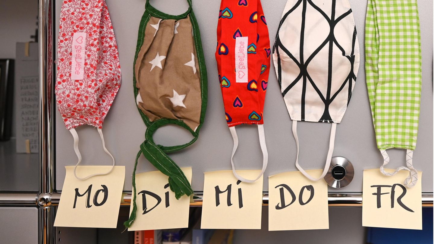 Selbstgenähte Mund- und Nasenmasken aus Stoff hängen in einem Büro an einem Aktenschrank