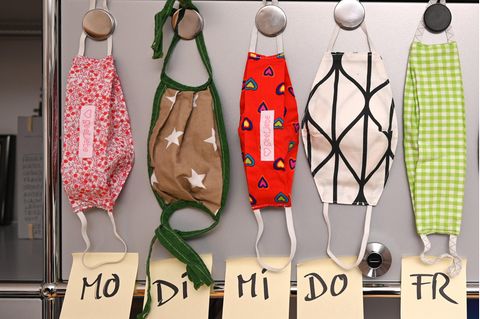 Selbstgenähte Mund- und Nasenmasken aus Stoff hängen in einem Büro an einem Aktenschrank
