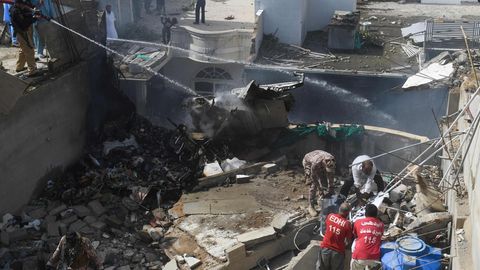 Feuerwehrleute löschen an der Absturzstelle in einem Wohngebiet in Karatschi