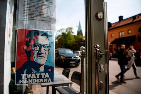 Ein Schild mit einem Porträt von Anders Tegnell hängt am Eingang eines Restaurants in Stockholm