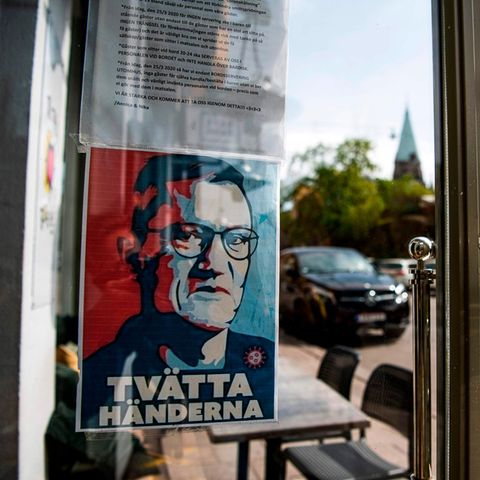 Ein Schild mit einem Porträt von Anders Tegnell hängt am Eingang eines Restaurants in Stockholm