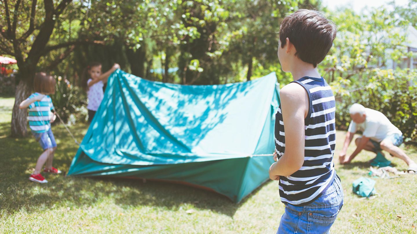 Kinder bauen ein Zelt auf