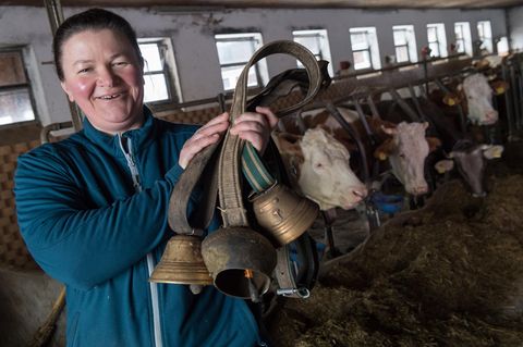 Milchbäuerin mit ein paar Kuhglocken in der Hand