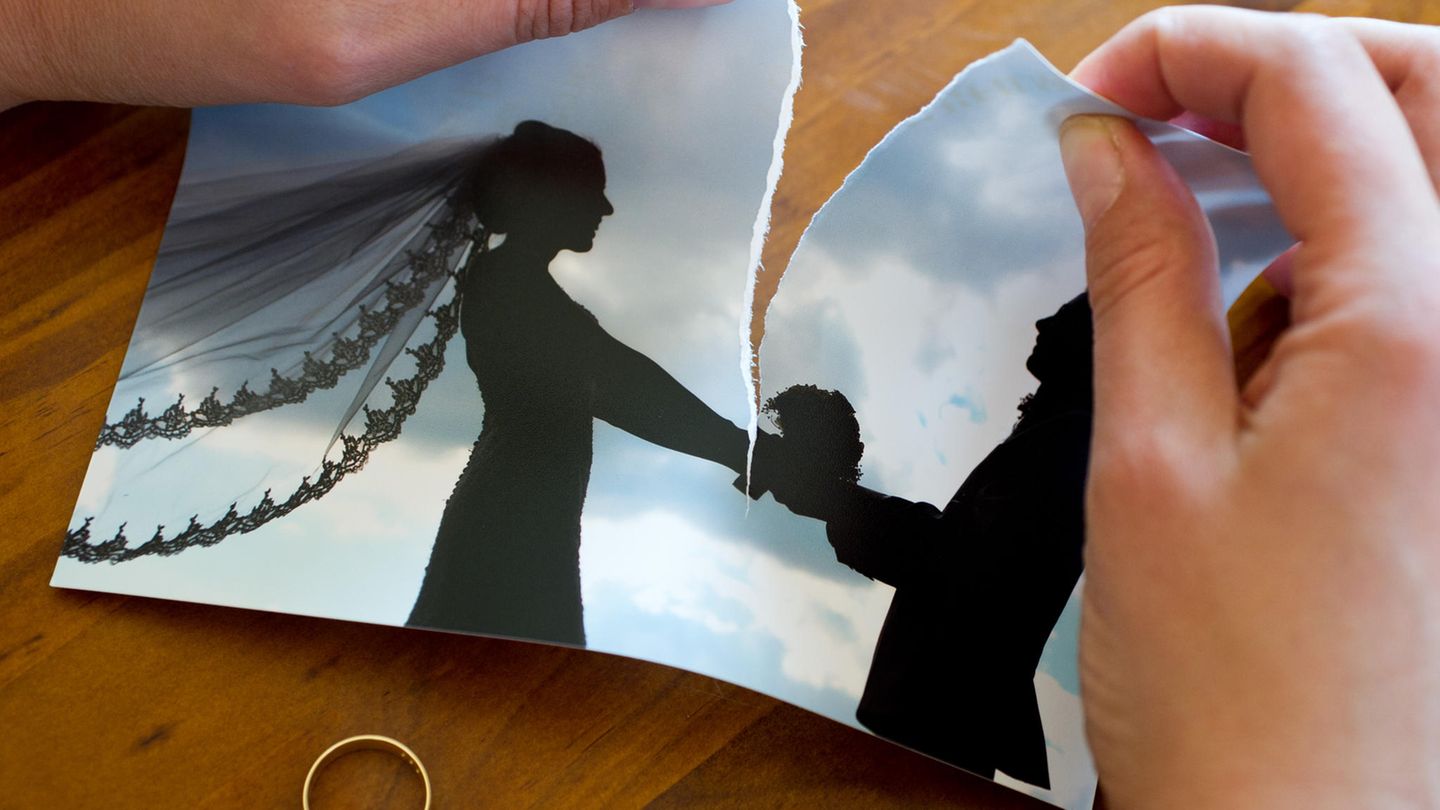 Hände zerreißen ein Hochzeitsfoto