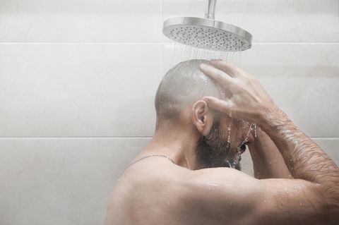 Ein Mann steht unter der Dusche