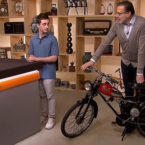 "Bares für Rares"-Experte Detlev Kümmel (r.) untersucht das Fahrrad von Nicholas Grossi. Moderator Horst Lichter würde am liebsten damit davonfahren.