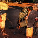 Ein Mann schöpft Wasser aus einem der Baumspeicher