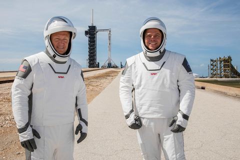 US-Astronauten Douglas Hurley und Robert Behnken mit Falcon-9-Rakete im Hintergrund