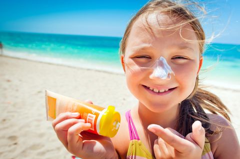 Ökotest Sonnencreme für Kinder im Test: Ein Mädchen benutzt eine Sonnencreme