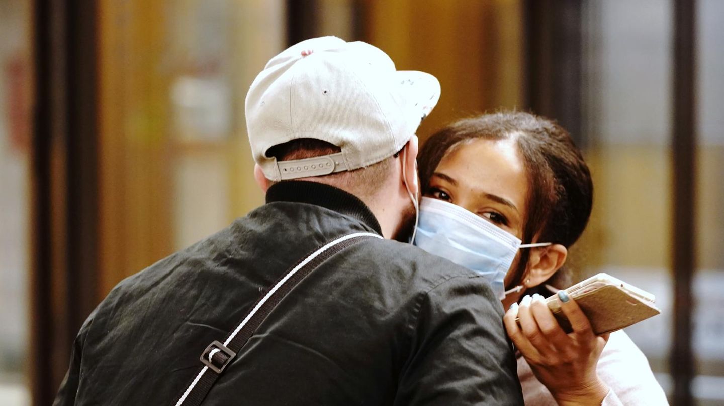 Begrüßung eines Paares mit Atemschutzmasken