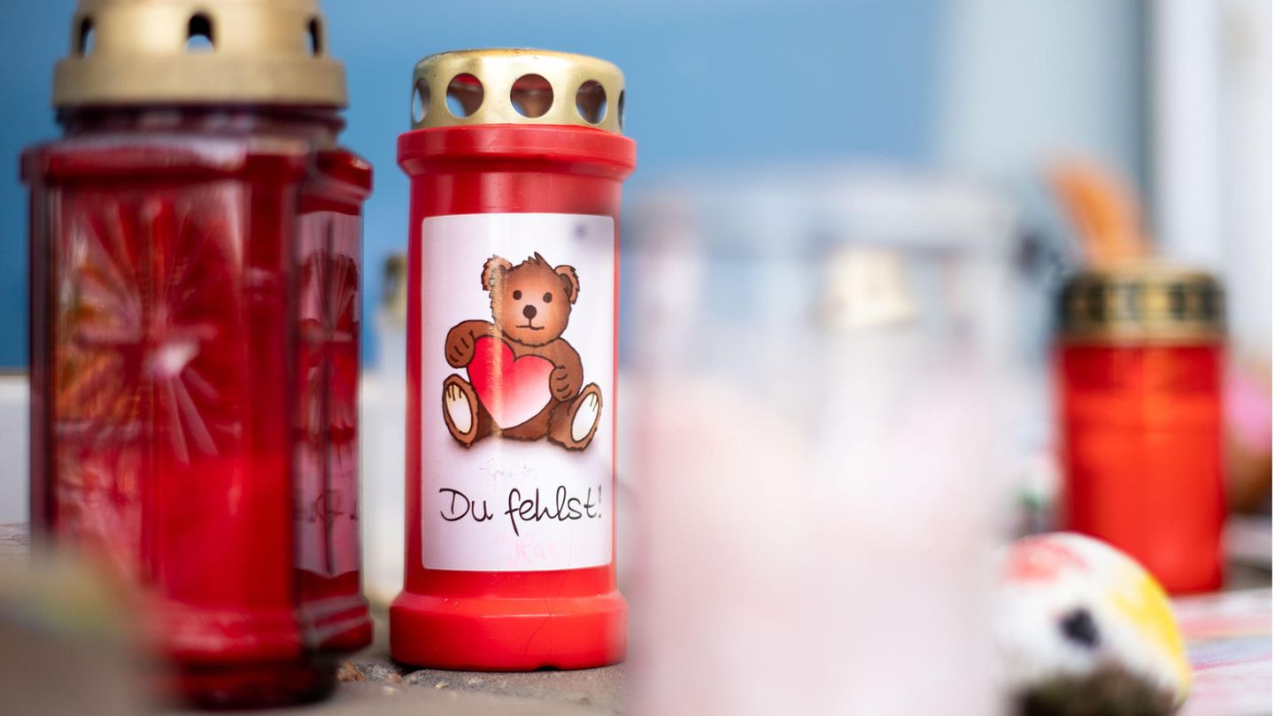 Grablichter mit gemalten Teddys stehen auf dem Boden