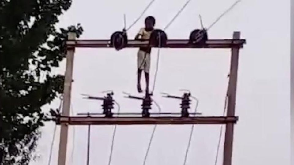Ein Junge aus Nordindien klettert auf einen acht Meter hohen Strommast Ein Junge aus Nordindien klettert auf einen acht Meter hohen Strommast