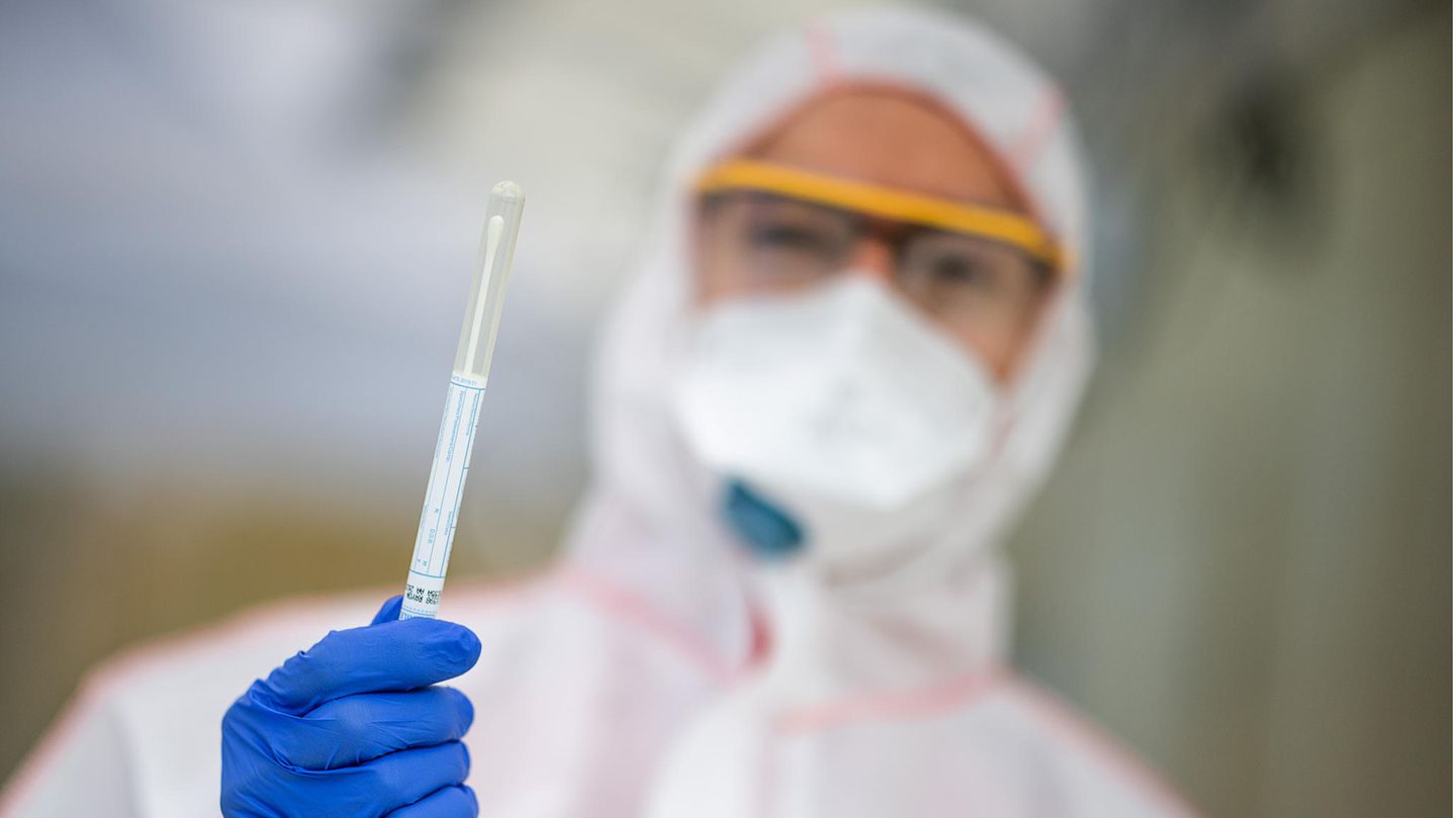 Coronatest: Mitarbeiter eines Gesundheitsamtes mit Abstrich-Probe in der Hand