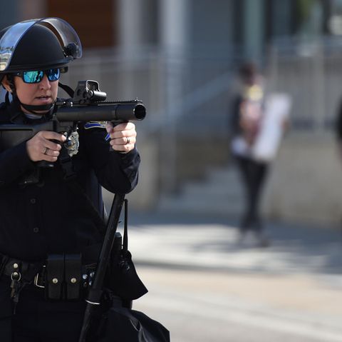 Polizist zielt mit Gummigeschoss