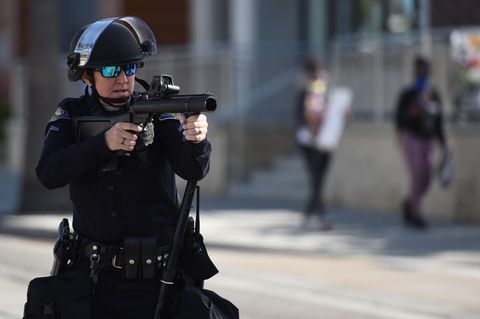 Polizist zielt mit Gummigeschoss