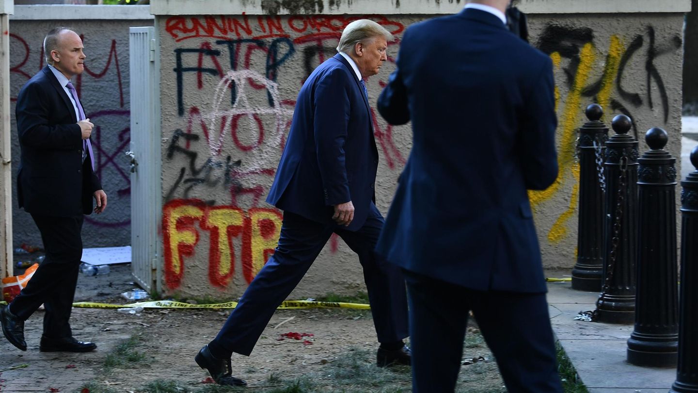 Donald Trump spaziert nach dem Besuch einer Kirche entlang einer mit Graffiti besprühten Mauer zurück ins Weiße Haus