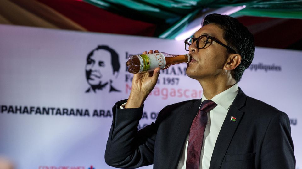 Madagaskars Präsident Andry Rajoelina nimmt einen Schluck vom angeblichen Heilmittel während einer Pressekonferenz im April