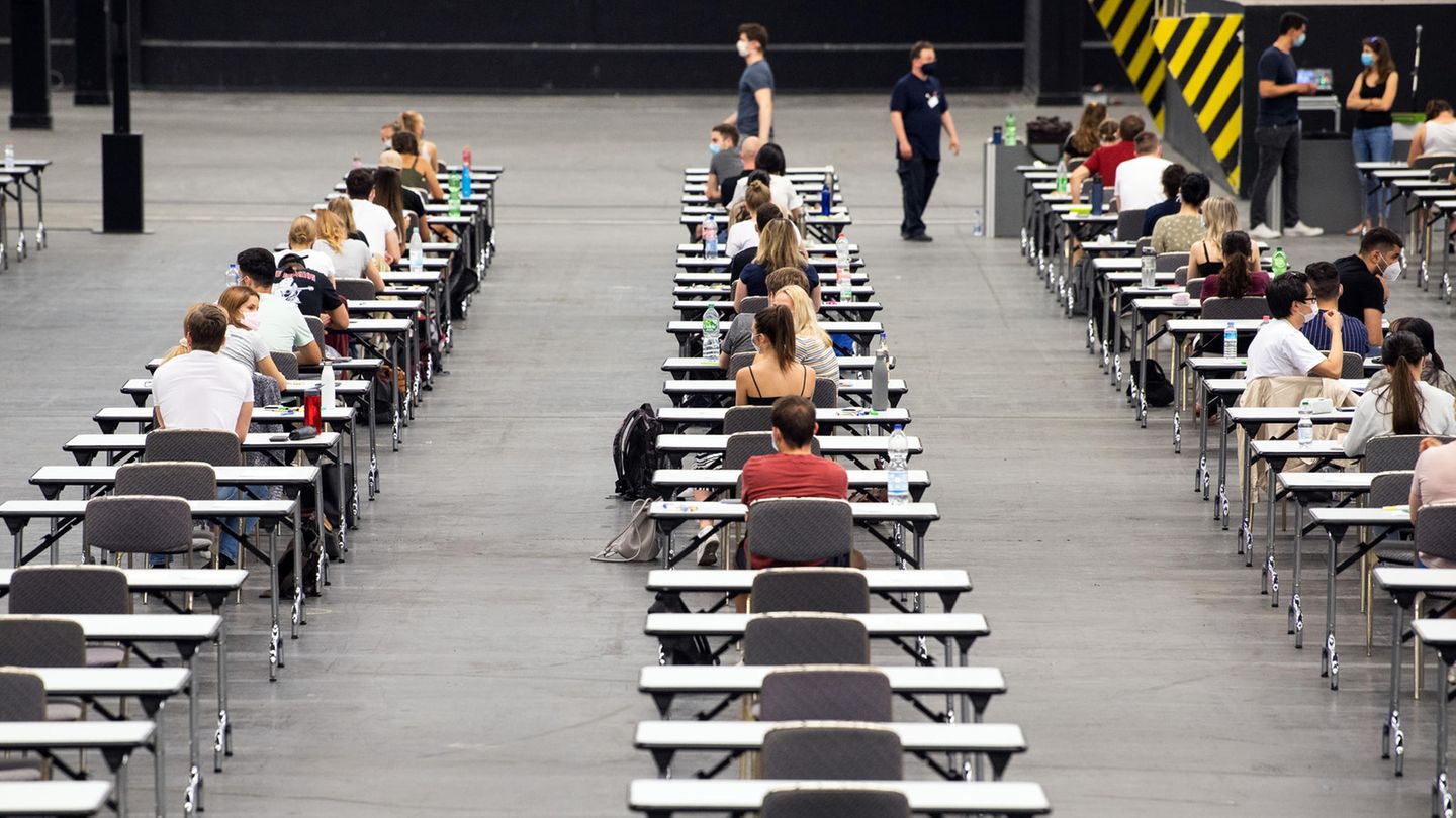 Studenten sitzen an Tischen mit großem Abstand