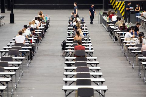 Studenten sitzen an Tischen mit großem Abstand