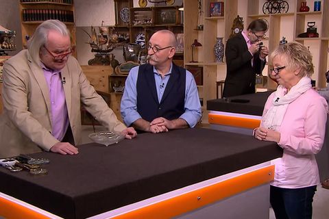 "Bares für Rares"-Experte Albert Maier gibt seine Einschätzung zu der Glasschale von Roswitha Eisenhut. Moderator Horst Lichter lauscht gebannt.