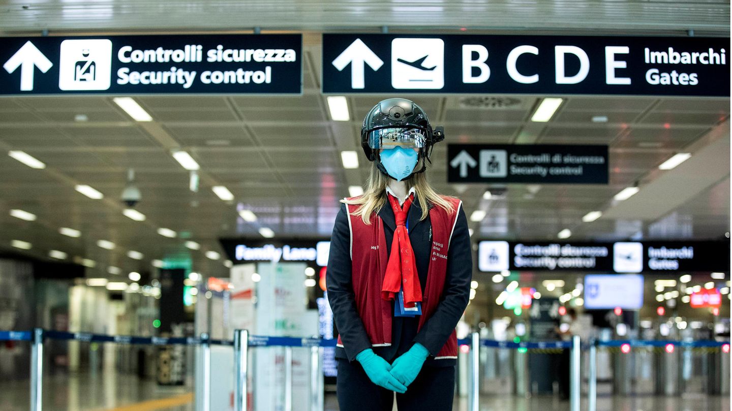 Die neue Normalität an Flughäfen weltweit: : Eine Mitarbeiterin des Flughafen Leonardo da Vinci in Rom trägt den neuen Smart Helmet zur automatischen Messung der Temperatur von Passagieren.