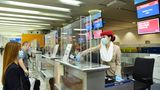 Arbeitsplatz Check-in: Die Mitarbeiterin am Flughafen Dubai wird durch eine Plexiglaskonstruktion am Counter geschützt.