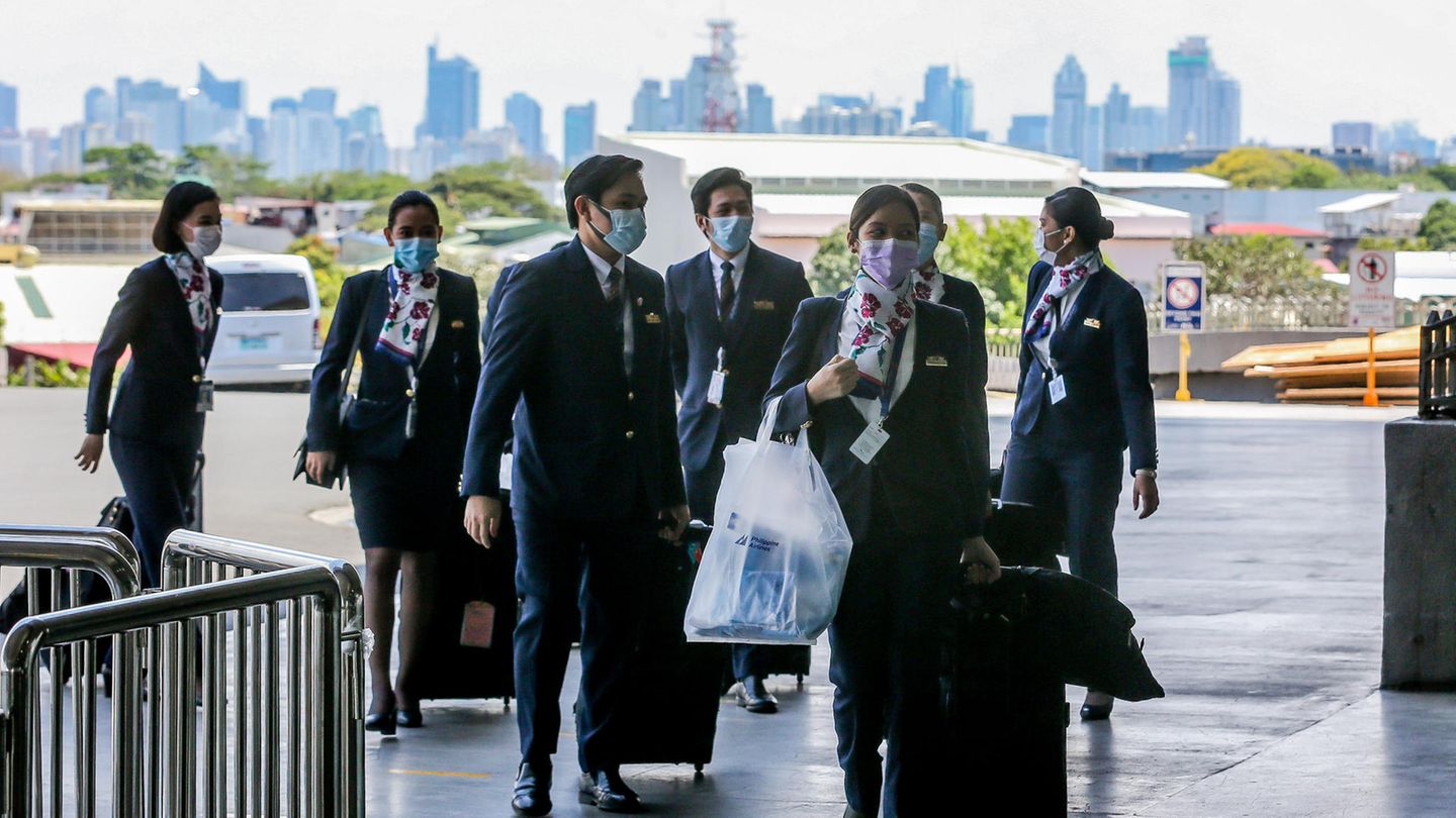 Eine Crew der Philippine Airlines kommt mit medizinischen Schutzmasken am Ninoy Aquino International Flughafen in Manila an. Alle Einreisenden müssen dort auf Covid-19 getestet werden