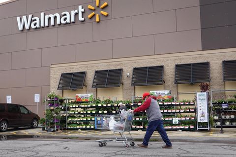 Ein Mann mit Einkaufswagen läuft vor einer Walmart-Filiale