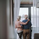 Älteres Paar schaut aus dem Fenster