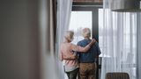 Älteres Paar schaut aus dem Fenster