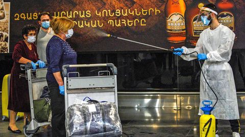Bild 1 von 20 der Fotostrecke zum Klicken: Willkommen in der neuen Welt des Reisens. Nach Ankunft in Armenien müssen sich Fluggäste in Jerewan vom Airport-Personal desinfizieren lassen.
