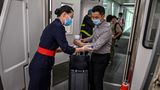 Bei diesem chinesischen Inlandsflug wird sogar vor Betreten der Kabine die Temperatur der Passagiere gemessen