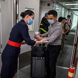 Bei diesem chinesischen Inlandsflug wird sogar vor Betreten der Kabine die Temperatur der Passagiere gemessen
