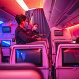 Nachtflug aus Sao Paulo in Brasilien nach Paris. Die Flugbleiter von Air France tragen Mund-Nasen-Schutz und verteilen in der Economy Class das Essen auf Tabletts.