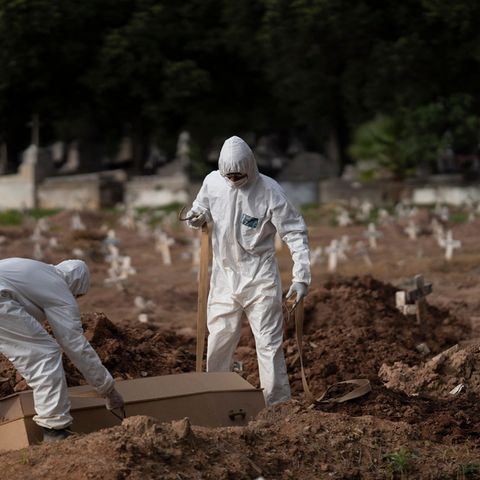 Brasilien, Rio De Janeiro: Friedhofsmitarbeiter in Schutzkleidung vergraben einen Sarg
