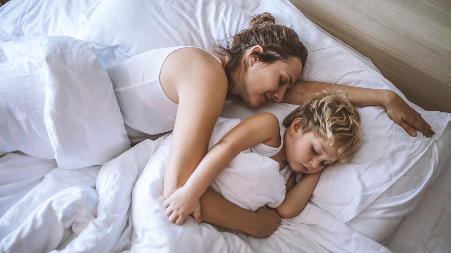 Mutter und Sohn schlafen im Bett