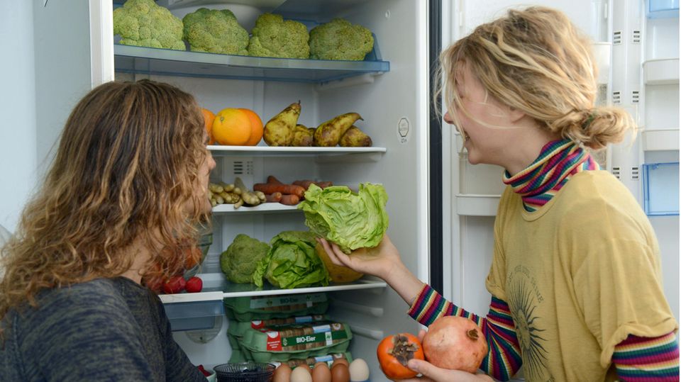 Lenny (l) und Freja nehmen Obst aus ihrem Kühlschrank, das sie aus den Abfallbehältern eines Supermarktes "gefischt" haben.