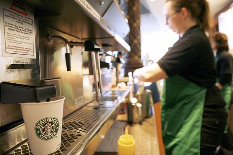 Mitarbeiterin von Starbucks macht einen Kaffee