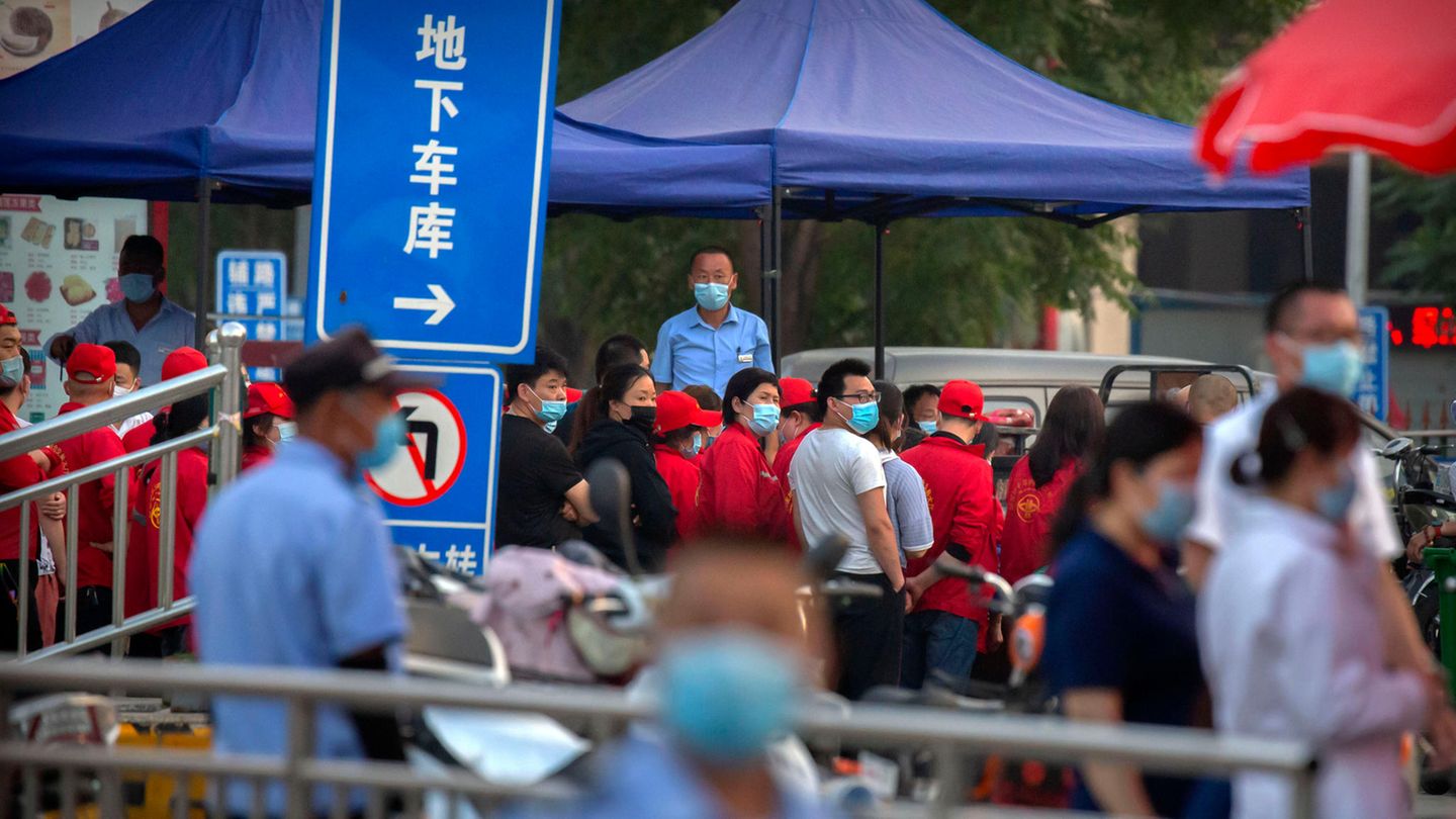 Polizisten sichern einen Fleischmarkt in Peking, der von den Behörden geschlossen wurde, nachdem bekannt geworden war, dass ein Besucher des Marktes positiv auf das Coronavirus getestet worden war.