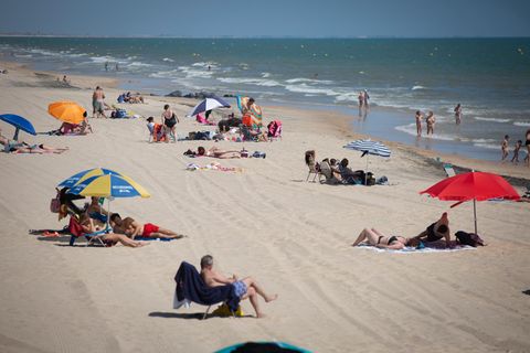 Menschen liegen und baden am Strand