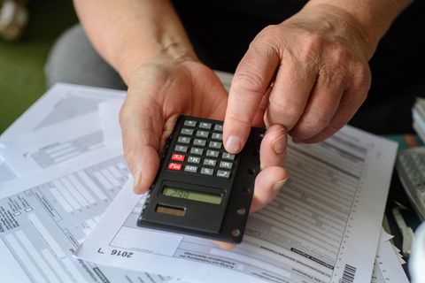 Ein Mann tippt angesichts der fälligen Steuererklärung in seinen Taschenrechner